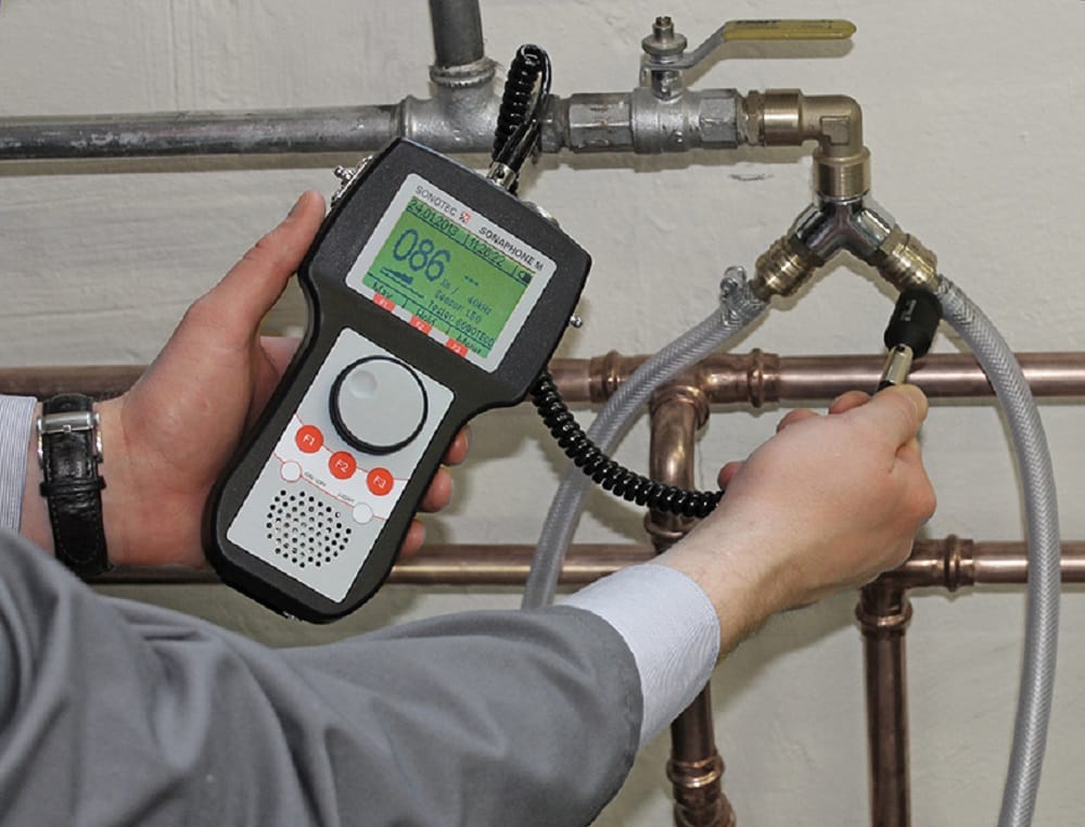 Plumber testing pipes with electronic leak detection equipment in Temecula