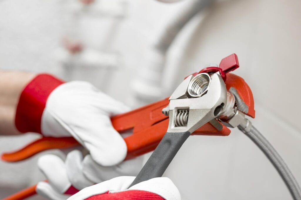 Plumber holding pipe wrenches for an emergency repair in Temecula