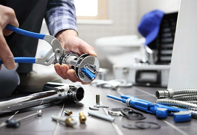 Technician repairing a plumbing fixture with professional tools in Temecula