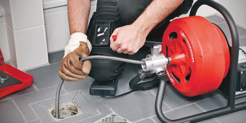 Plumber using a drain-cleaning machine in Temecula
