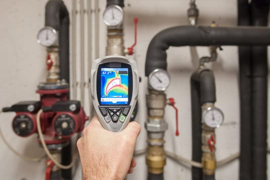 Plumber using a thermal imaging camera to inspect pipes in Temecula