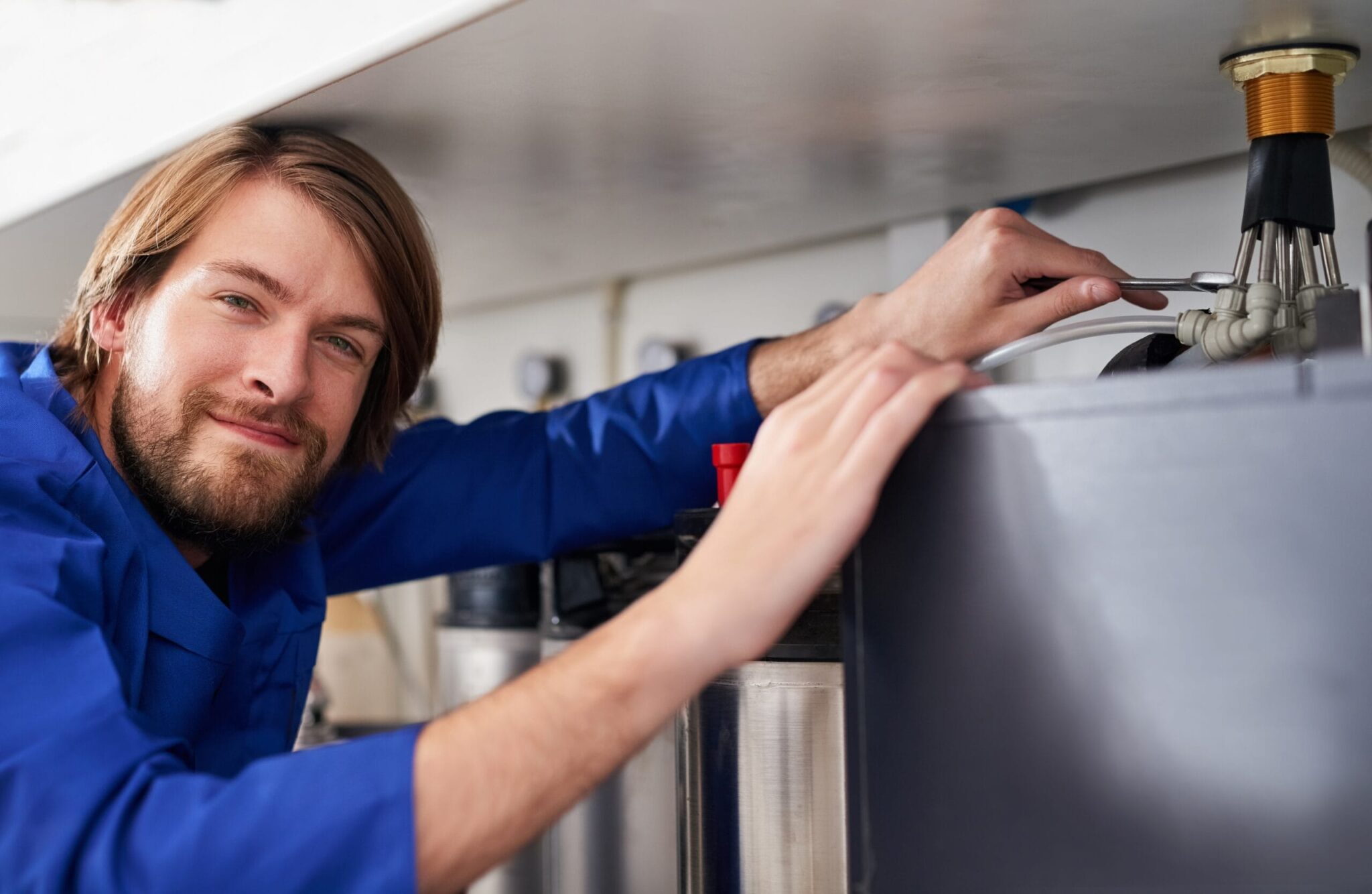 Technician servicing a residential water heater tank in Temecula
